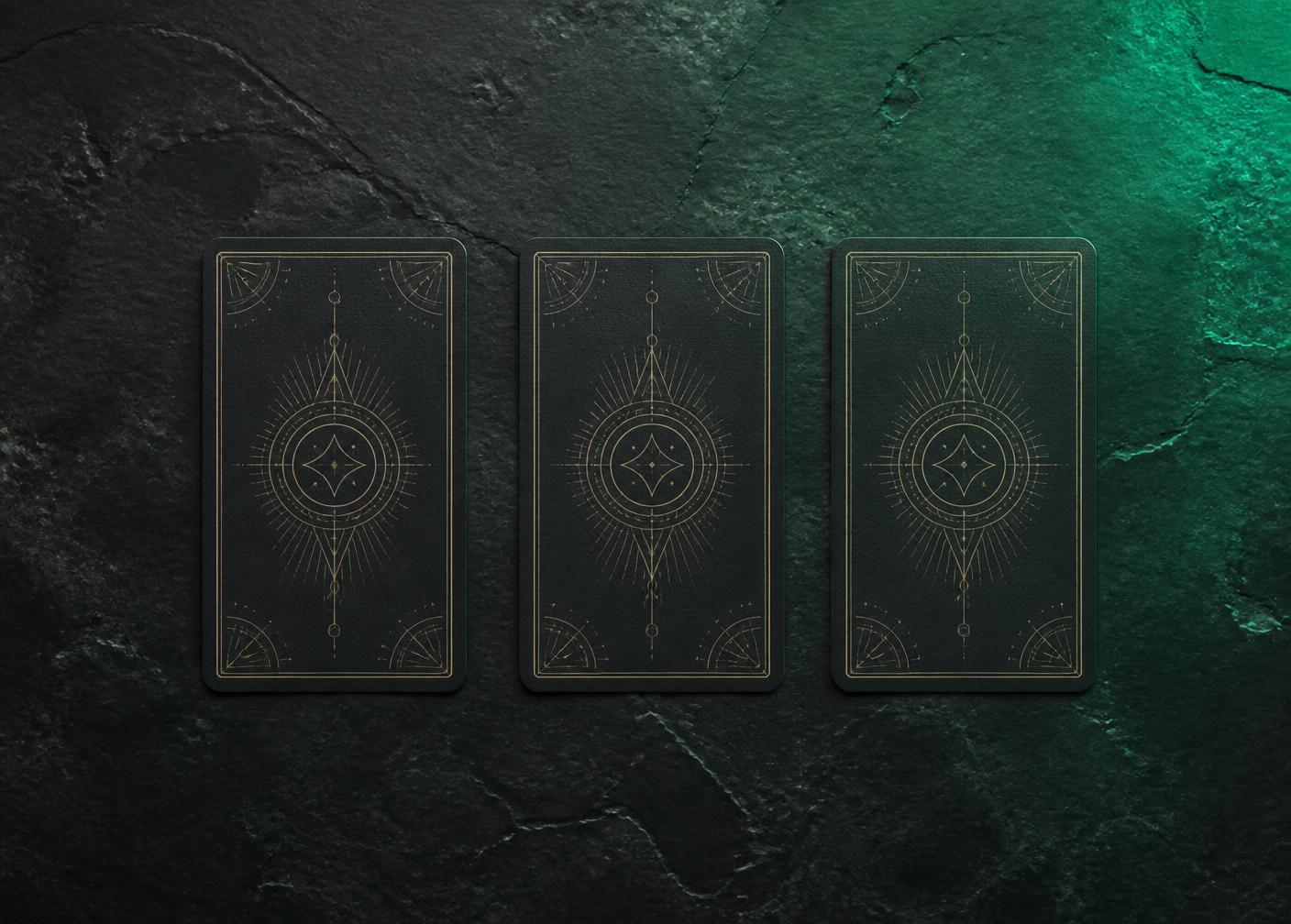Three tarot cards face down on dark stone